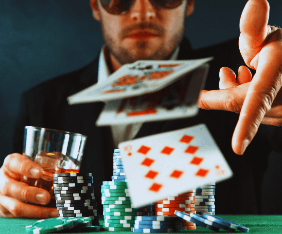 cartas de baralho sendo jogadas por um homem em cima de uma mesa de jogos com fichas de cassino